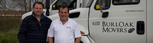 BurlOak Movers founders standing in front of a moving truck